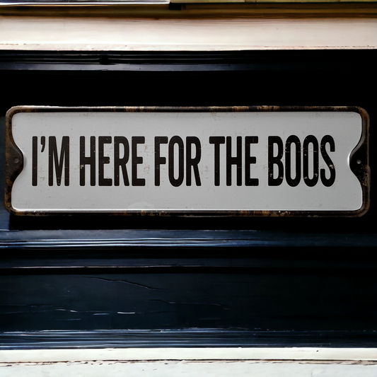 Halloween sign, that reads I'm here for the boos, place on a black wooden wall