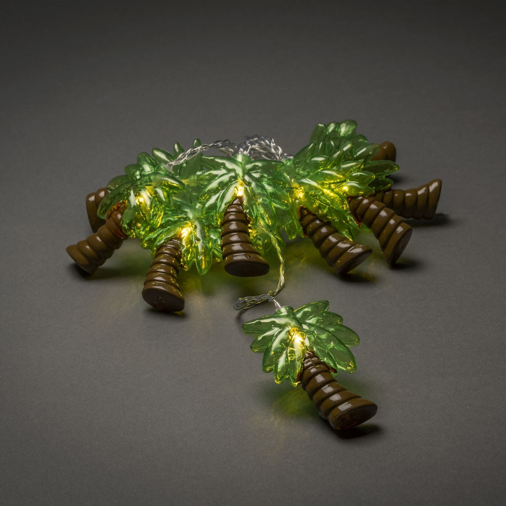 palm tree lights lay out in a cluster on a plain grey background with the LED's on