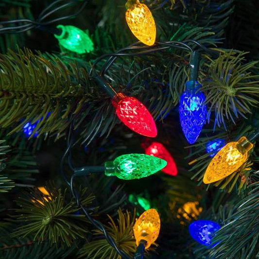 multicoloured faceted cone lights shown entwined in a green Christmas tree branch